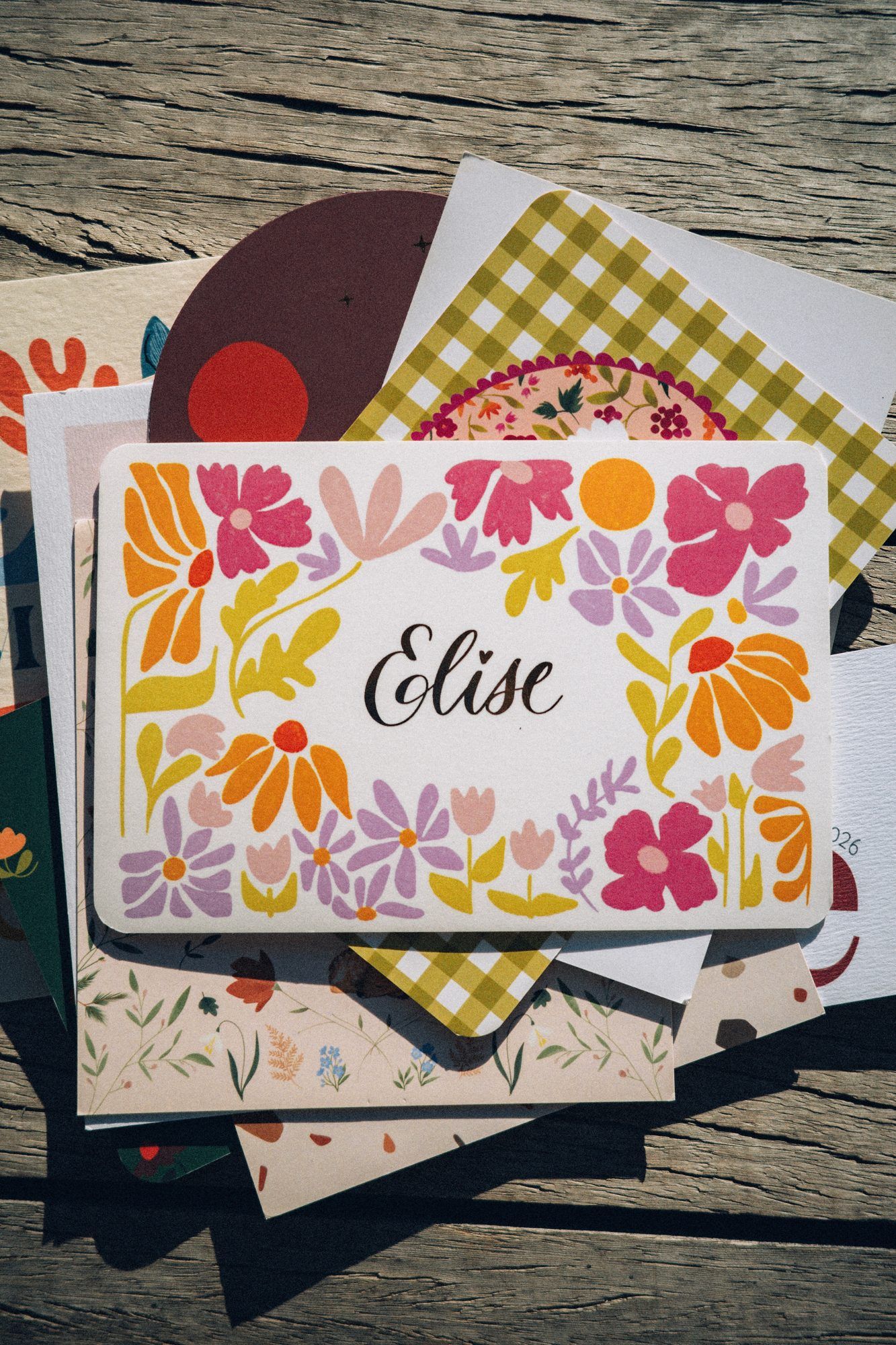 Faire-part de naissance d'Elise aux grandes fleurs colorées, posé sur d'autres créations